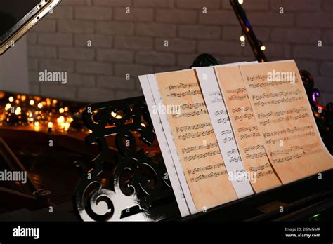 Piano with notes and Christmas lights in room Stock Photo - Alamy