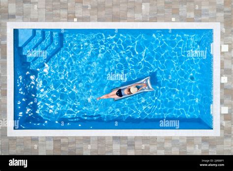 Woman Lying On Raft In Swimming Pool Stock Photo Alamy