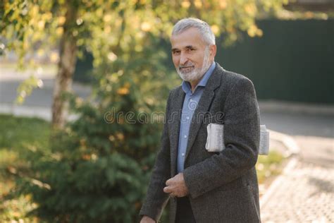 Un Uomo Anziano Di Lusso Cammina Per Il Parco Con Un Giornale A Mani Nude Il Nonno Barbuto La
