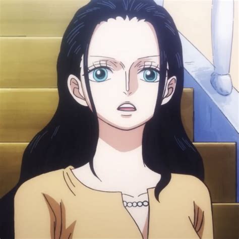 A Woman With Long Black Hair And Blue Eyes Standing In Front Of Some