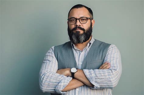 A Man With Glasses And A Beard Stands With His Arms Crossed Premium Ai Generated Image