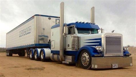 A Large Semi Truck Parked On Top Of A Dirt Field