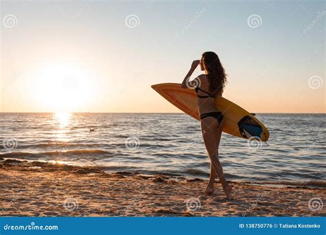 A Menina De Cabelo Escuro Magro Em Um Roupa De Banho Anda No Sandy