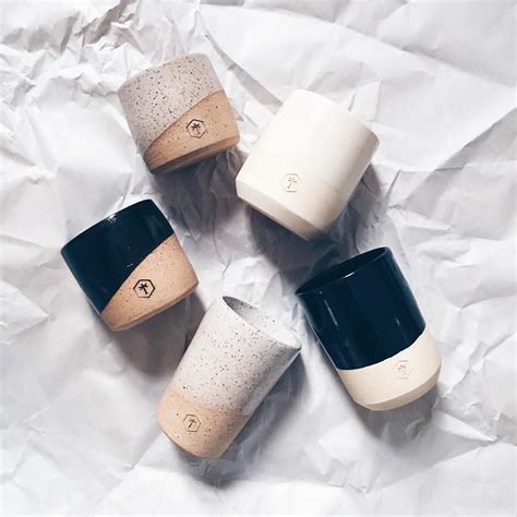 Four Coffee Cups Sitting On Top Of A White Paper Covered Table Next To