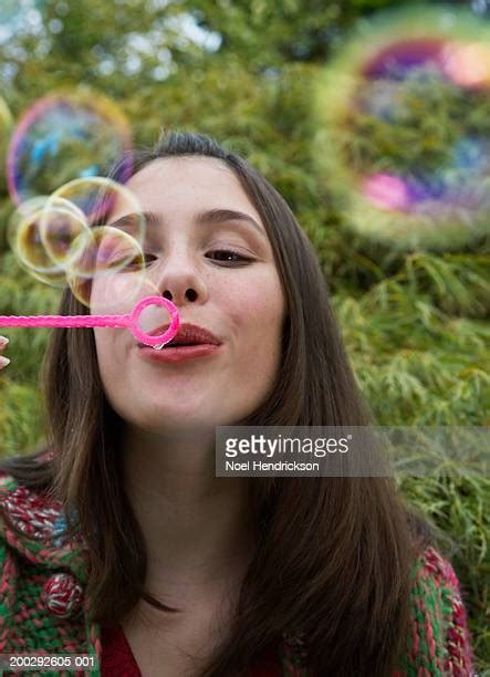 Teenage Girl Blowing Soap Bubbles Through Bubble Wand Closeup High Res