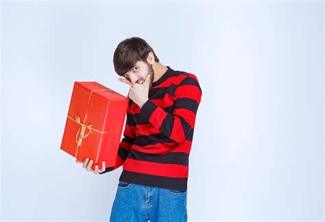 El Hombre Con Camisa De Rayas Rojas Sosteniendo Una Caja De Regalo Roja