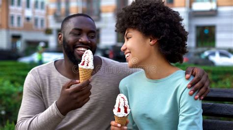 Dating Couple Eating Ice Cream Sitting On City Bench Having Fun