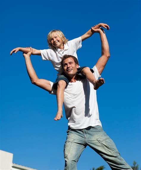 Joven Padre Con Su Hijo En La Espalda Al Aire Libre Foto Premium