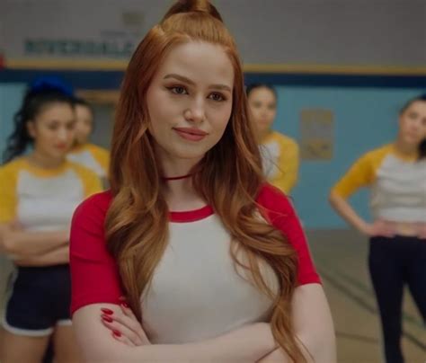 A Woman With Long Red Hair Standing In Front Of Other Women Wearing