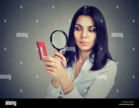 Curious Business Woman Looking At Credit Card Through Magnifying Glass