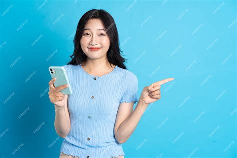 Premium Photo Portrait Of Smiling Asian Woman Posing On Blue Background