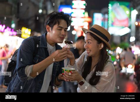 Asian Couple Tourist Backpacker Enjoying And Eating Street Food In