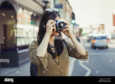 Young Female Tourist Photographing With Camera On Urban Street Stock