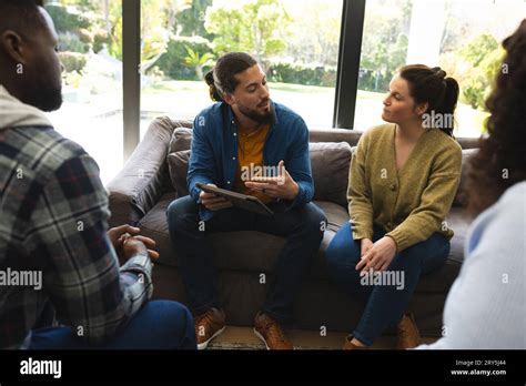 Diverse Group Of Friends And Male Therapist With Tablet In Group