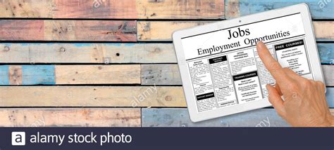 Online Job Hunting Hand With Computer Tablet Reading Employment Ads On Table Recruitment