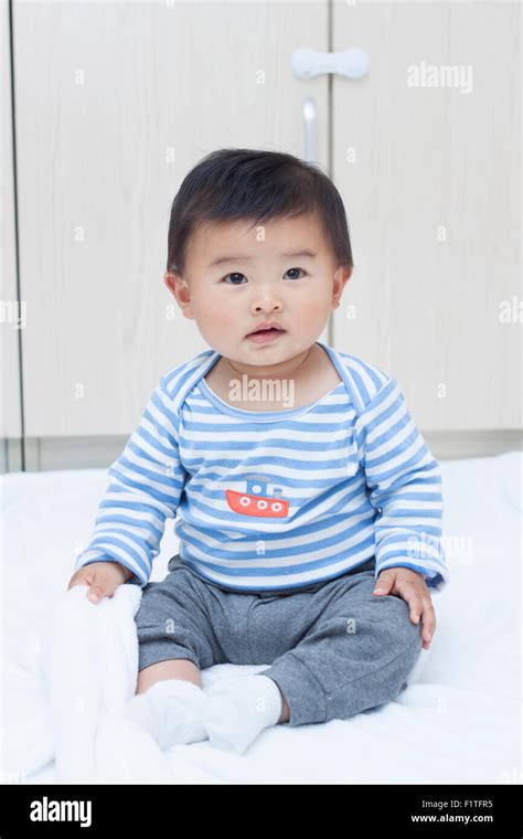 Cute Chinese baby boy sitting on a white blanket Stock Photo - Alamy