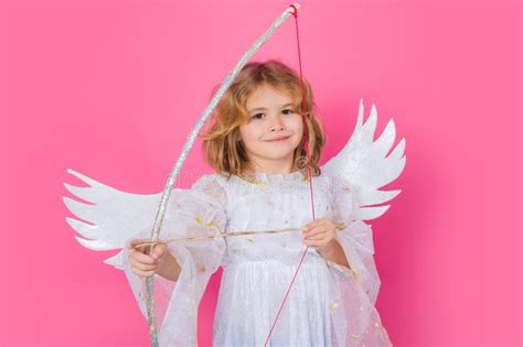 Angel Kid Shoots a Love Arrow from a Bow on Valentines Day. Cute Angel Child, Studio Portrait ...