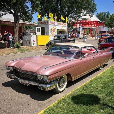 An Old Pink Car Parked In Front Of A Gas Station