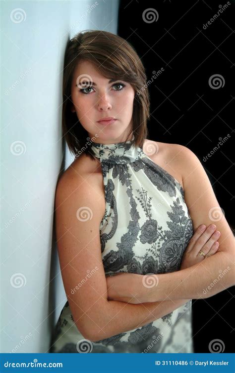 Pretty Woman With Arms Folded Leaning Against Wall Stock Photo Image