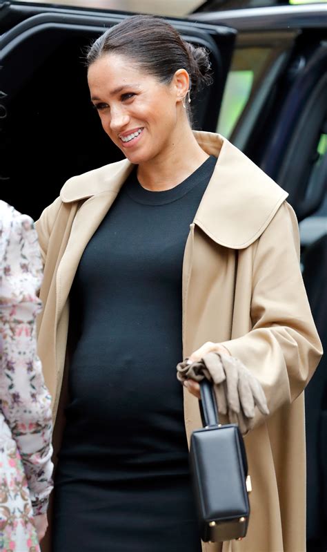 Meghan Markle Shows Off Six Month Baby Bump In Tight Fitting Black Dress