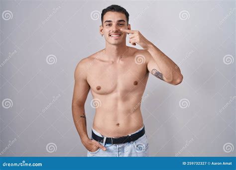 Handsome Hispanic Man Standing Shirtless Pointing With Hand Finger To