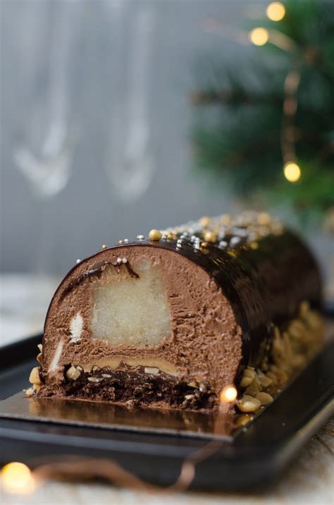 A Piece Of Cake Sitting On Top Of A Black Plate Next To A Christmas Tree