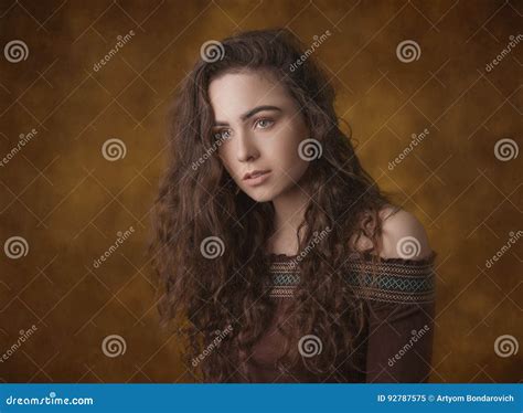 Dramatic Portrait Of A Young Beautiful Brunette Girl With Long Curly