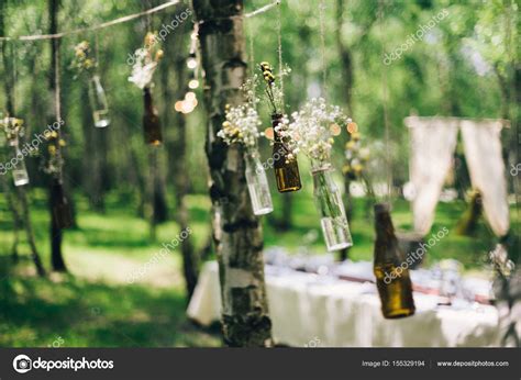 Bouteilles avec des fleurs des arbres de décoration dans la forêt