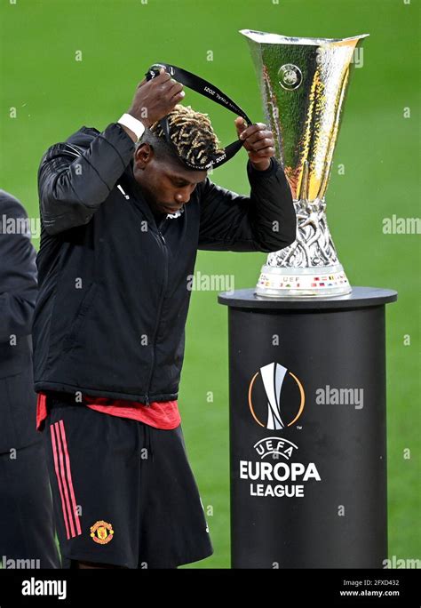 Manchester United's Paul Pogba walks past the UEFA Europa League trophy ...