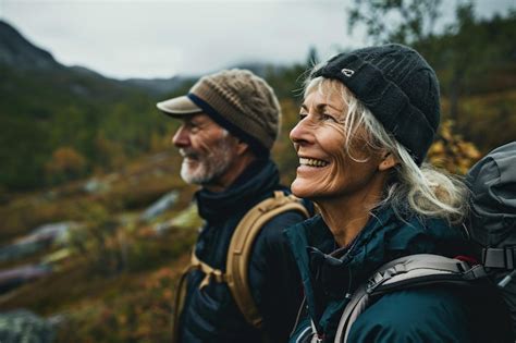 Senior Hikers With Backpacks Standing On Mountain Trail Looking At