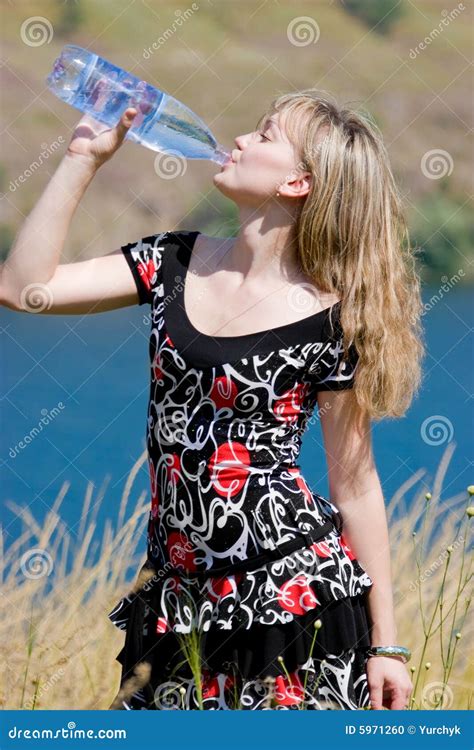 Eau Potable De Jeune Fille De Bouteille En Plastique Photo Stock