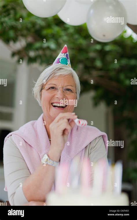 Older Woman Laughing At Birthday Party Stock Photo Alamy