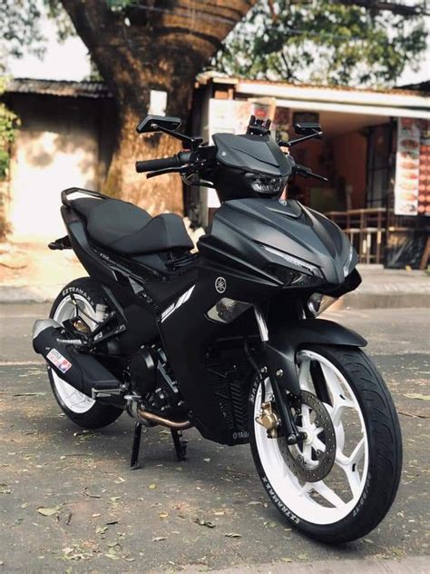 A Black Motorcycle Parked In Front Of A Tree