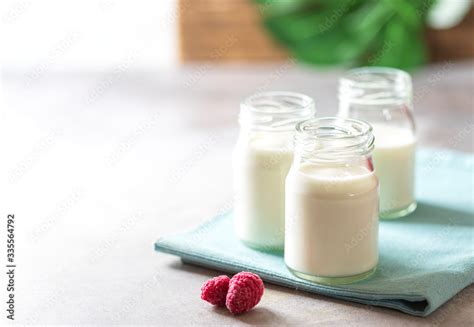 Fermented drink kefir in a glass jar on a light background. Probiotic ...