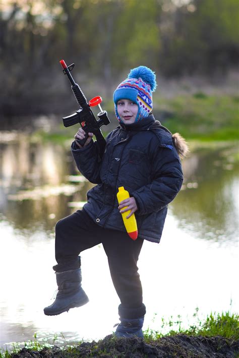 A young boy is holding a toy gun photo – Free Boy Image on Unsplash