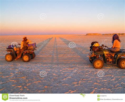 Tourist And Guide On Quad Bikes Stop While Crossing Makgadikgadi Pans