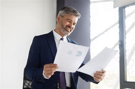 Premium Photo Happy Middle Aged Entrepreneur Reading Business Papers