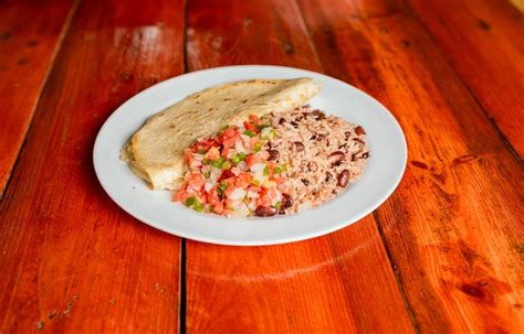 Plato De Gallopinto Con Quesillo Y Pico De Gallo Sobre Mesa De Madera