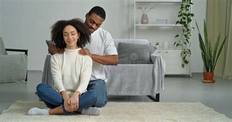 Afro American Couple At Home Dark Skinned Caring Man Husband Boyfriend Massages Shoulders Of His