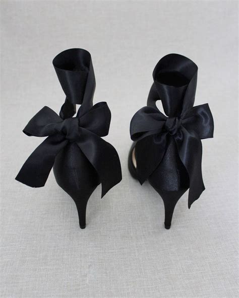 two pairs of black shoes with bows on them