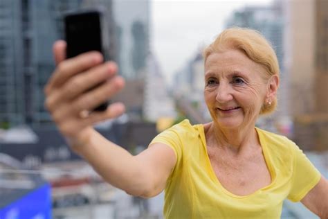 Premium Photo Portrait Of A Smiling Young Woman Using Mobile Phone