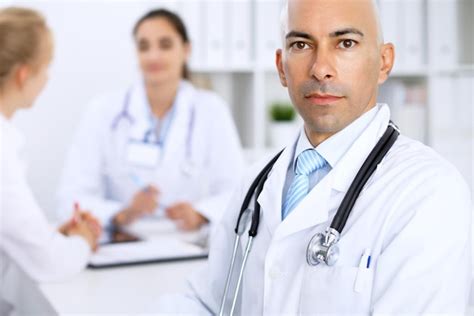 Premium Photo Confident Bald Doctor Man With Medical Staff At The