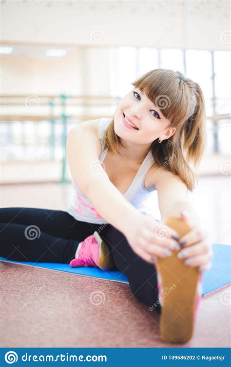 La Mujer Que Hace Estirar Ejercita En El Piso En El Gimnasio Foto De