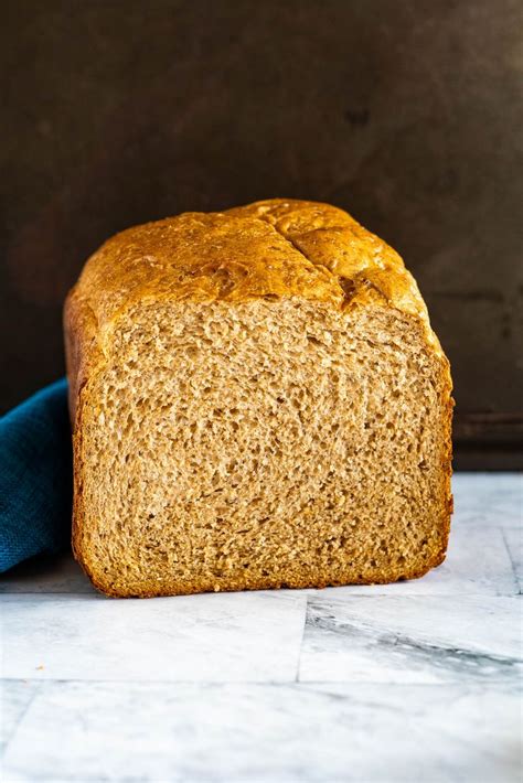 a loaf of bread sitting on top of a counter next to a blue cloth and a knife