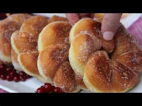 Someone Is Picking Up Some Sugared Doughnuts On A White Plate With