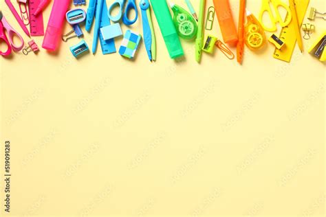 Colorful rainbow school supplies on yellow background. Frame border, top view. Flat lay. Back to ...