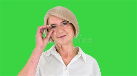 Mature Grandmother Sitting And Knitting And Telling A Story To Camera