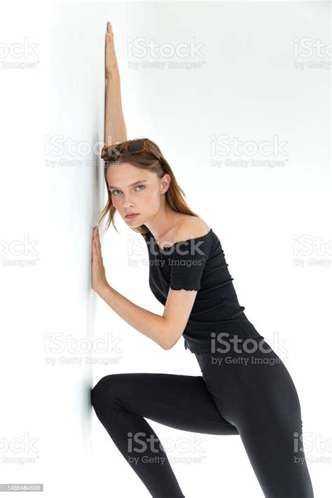 Blonde Freckled Girl Wearing Black Blouse And Tights Against White