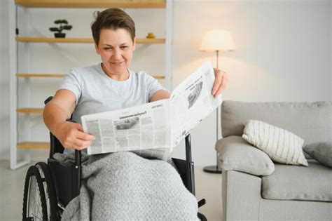 Mujer en silla de ruedas leyendo el periódico en el interior Foto Premium