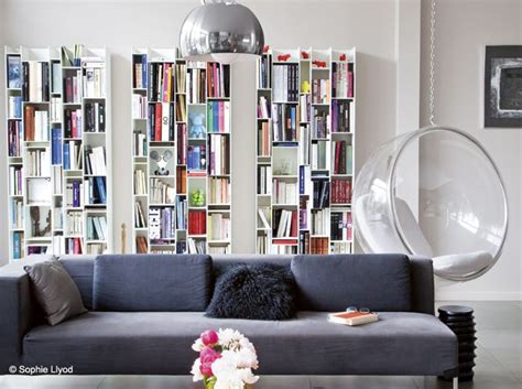 A Living Room Filled With Furniture And Bookshelves Next To A Glass